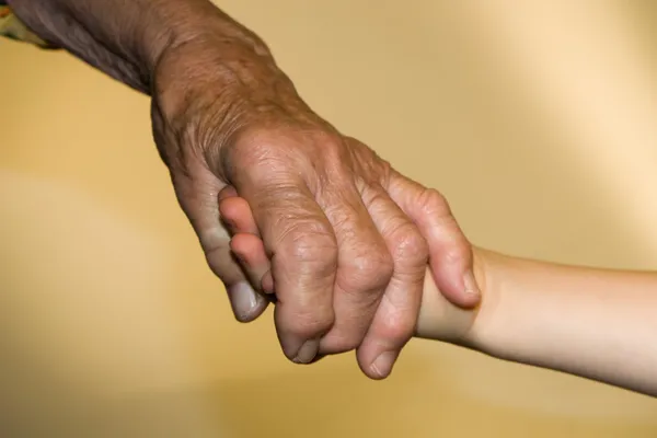 Manos del adulto mayor y del niño — Foto de Stock