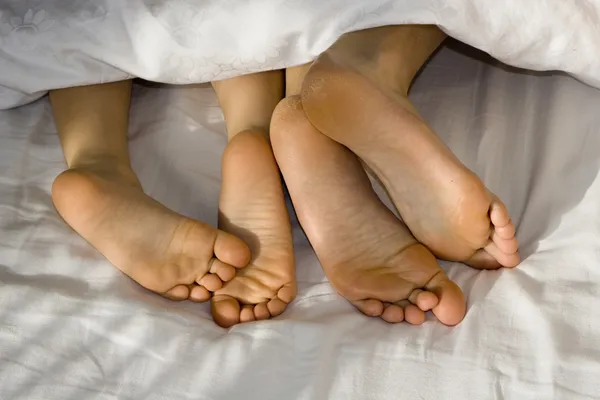 Feet in bed - mother and daughter — Stock Photo, Image