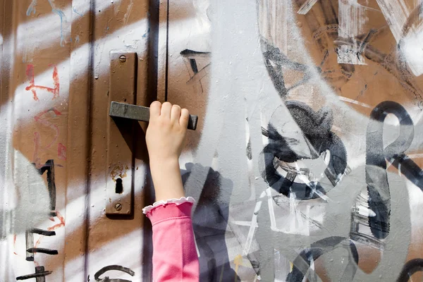 Curiosity of little girl - hand and door of street — Stock Photo, Image