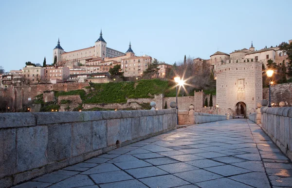 Toledo - alcazar a svatý martin most v ranním šeru — Stock fotografie