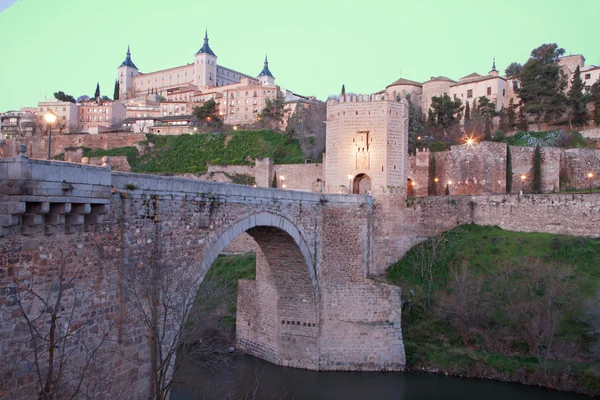 Toledo - alcazar och punte alcantara-bron i morgon skymning — Stockfoto