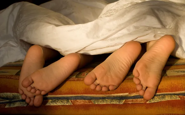 Feet of sisters in the bed — Stock Photo, Image