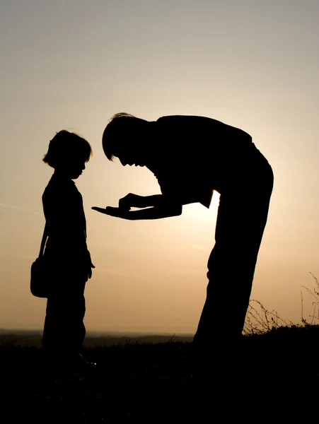 Dialog of mother and child in sunset - silhouette — Stock Photo, Image