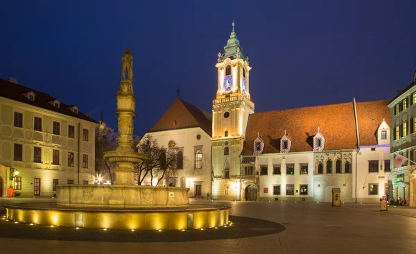 Bratislava, Slovakya - ö. 23 Ocak 2014: akşam karanlığında Belediye Binası ve Cizvitler Kilisesi ile ana meydanında.