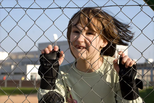 Portrait of little girl and fence — Stock Photo, Image