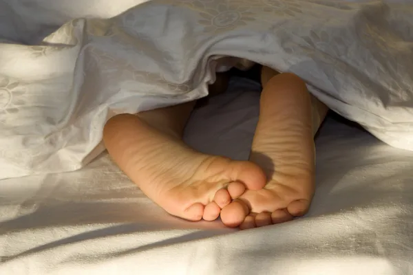 Pies de niña en la cama —  Fotos de Stock