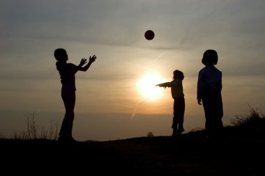 Günbatımında Topla oyna - siluet