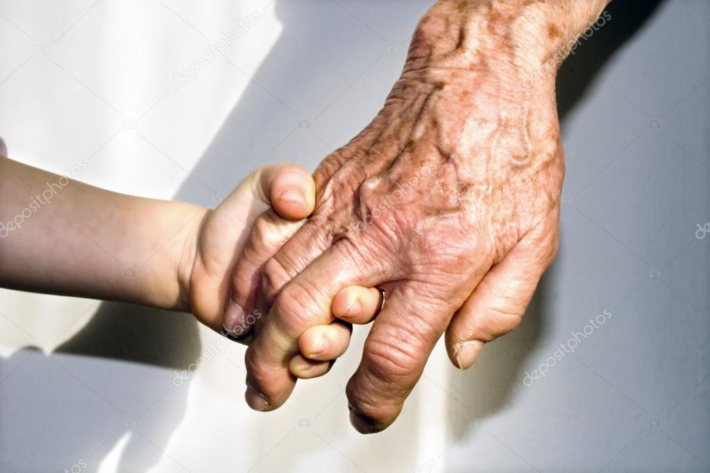 Hand of grandmother and grandchild