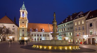 Bratislava, Slovakya - ö. 23 Ocak 2014: akşam karanlığında Belediye Binası ve Cizvitler Kilisesi ile ana meydanında.