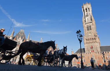 BRUGGE, BELGIUM - 13 Haziran 2014: The Carriage on the Grote Markt and Belfort van Brugge.