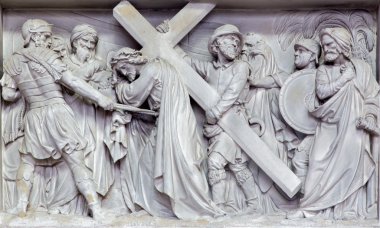 MECHELEN, BELGIUM - JUNE 14, 2014: Stone relief Simon of Cyrene help Jesus to carry his cross  in church Our Lady across de Dyle. clipart
