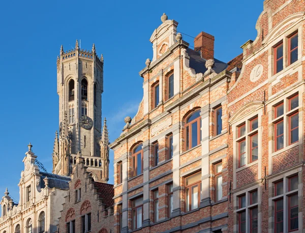 Brujas - Fachada de casas tipicas con la torre Belfort van Brugge en el fondo . —  Fotos de Stock