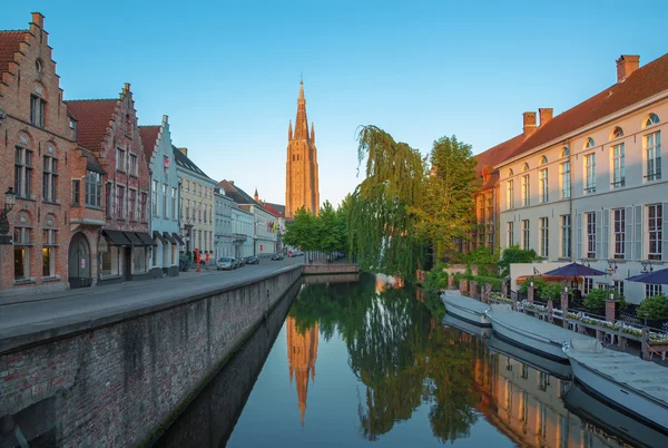 Brugge - kijken naar het kanaal van sint jan nepomucenus brug met de toren van onze Vrouwe kerk in ochtend licht. — Stockfoto