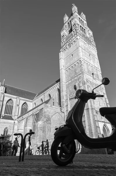 Bruges, Belgien - 13. Juni 2014: St. Salvator 's Cathedral (salvatorskerk) von Westen und Silhouette eines Motorrollers im Abendlicht . — Stockfoto