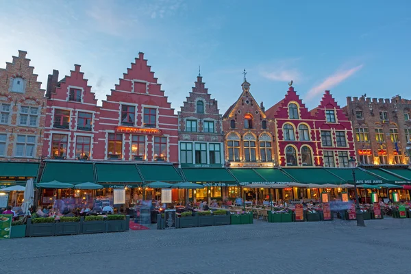 Brugia, Belgia - 12 czerwca 2014: Domy grote markt kwadrat o zmierzchu. — Zdjęcie stockowe