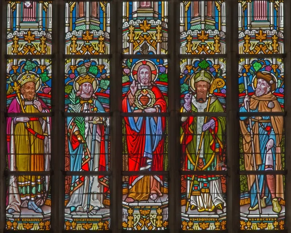 MECHELEN, BÉLGICA - 14 DE JUNIO DE 2014: El corazón de Jesús y los santos en el cristal de la ventana en la iglesia de Santa Catalina o Katharinakerk . —  Fotos de Stock