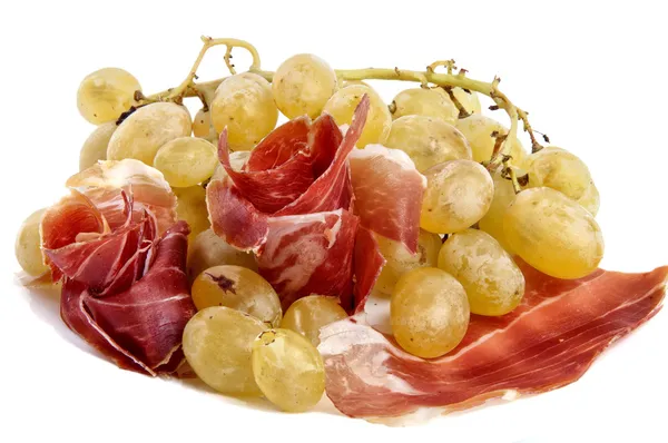 Raisins blancs avec des roses de jambon sur un fond blanc — Photo