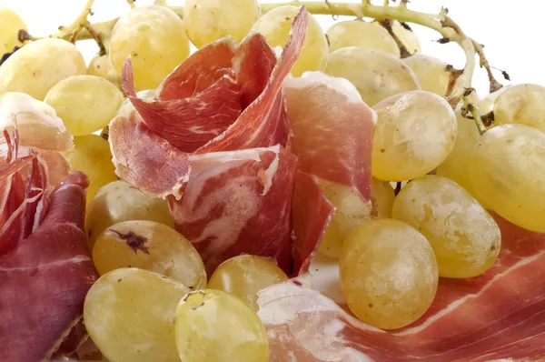 Raisins blancs avec des roses de jambon sur un fond blanc — Photo