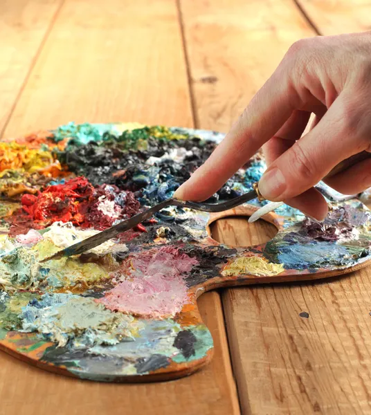 Hand with palette-knife and palette — Stock Photo, Image