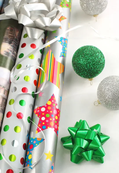 Christmas gift wrapping papers with ribbon and supplies.