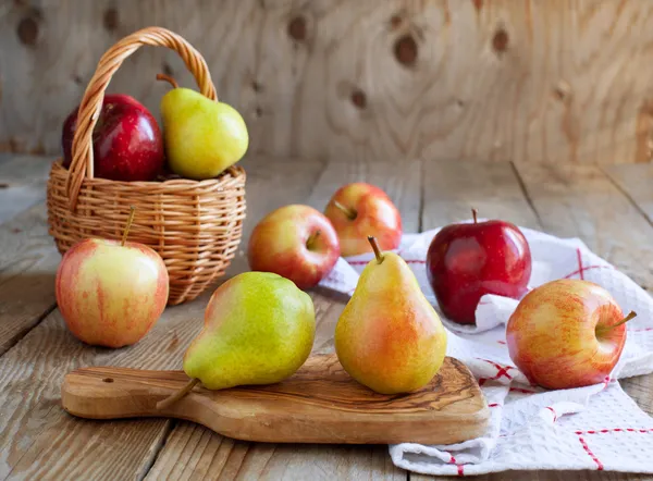 Fresh ripe pears and apples on wooden table — Stock Photo, Image