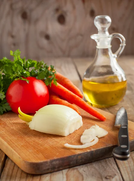 Zwiebel, Karotten und frische Petersilie auf einem Schneidebrett. — Stockfoto