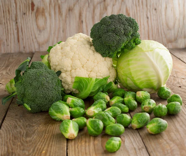 Still life with assortment cabbages on wooden background — Stock Photo, Image