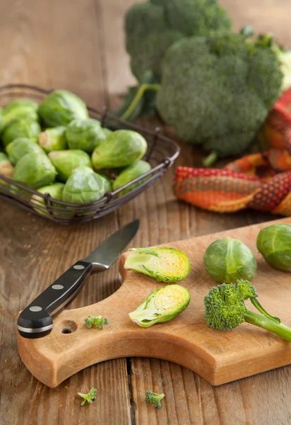 Spruiten en broccoli op houten tafel — Stockfoto