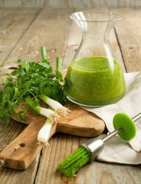 Glasflasche mit grünem Olivenöl und grüner Zwiebel mit Petersilie — Stockfoto