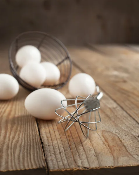 Metal whisk and fresh eggs — Stock Photo, Image