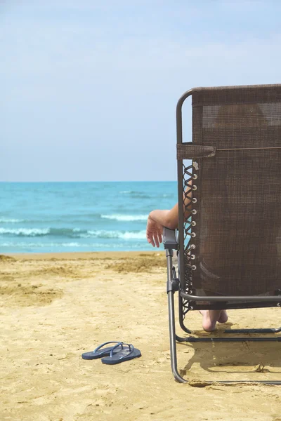 Жінка розслабляється на пляжному кріслі — стокове фото