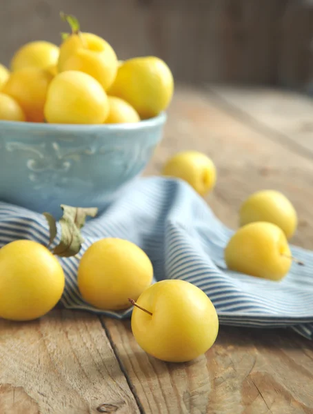 Ciruelas amarillas en tazón azul — Foto de Stock