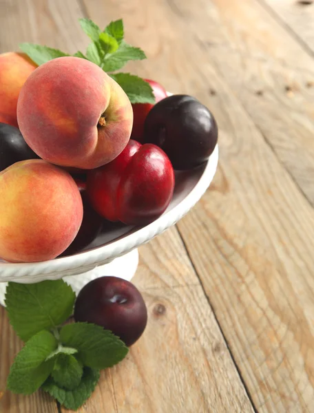 Färska persikor, nektariner och plommon i vas — Stockfoto