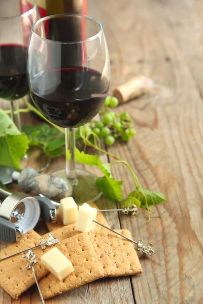 Glasses of red wine with cheese, crackers and grape — Stock Photo, Image