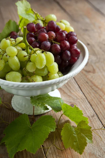 Trauben in der Vase auf einem Holztisch — Stockfoto