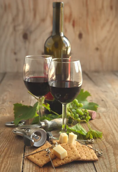 Glasses of red wine with cheese, crackers and grape — Stock Photo, Image