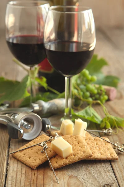 Queijo e bolachas com copos de vinho tinto — Fotografia de Stock