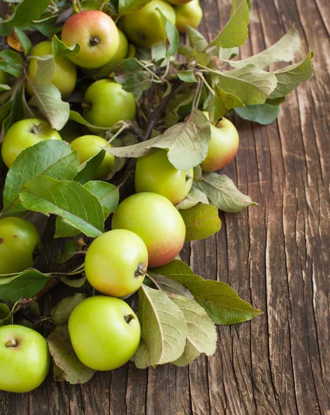 Органические яблоки с листьями на деревянном фоне — стоковое фото