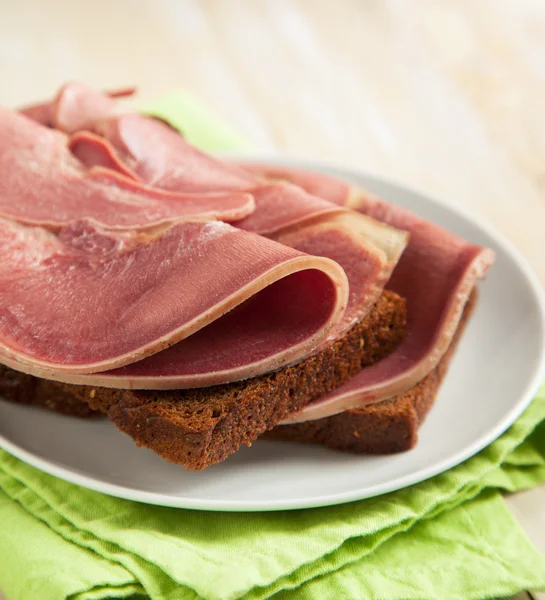 Open sandwiches with sliced cold neat's tongue — Stock Photo, Image