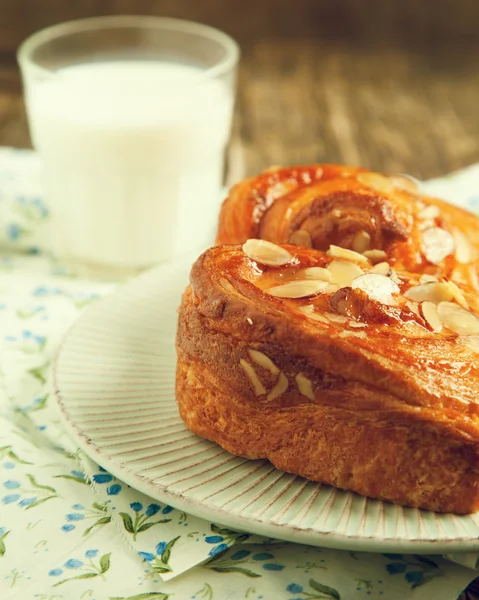 Pastelería danesa de almendras en plato con vaso de leche —  Fotos de Stock