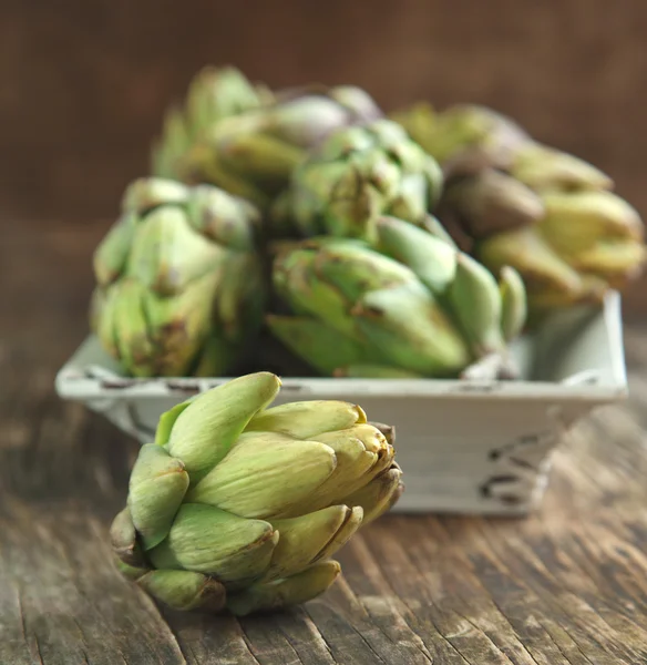 Verse artisjokken op houten ondergrond — Stockfoto