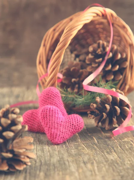 Conos de pino y corazones de ganchillo hechos a mano en cesta — Foto de Stock