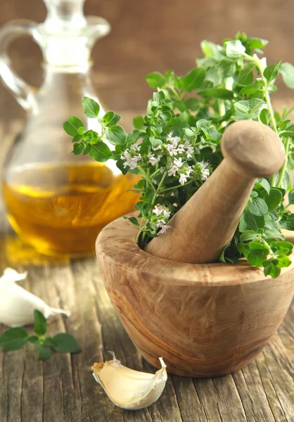 Oregano herb in wooden mortar and pestle. — Stock Photo, Image