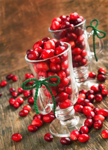 Ripe cranberries in glass cup on wooden background — Stock Photo, Image