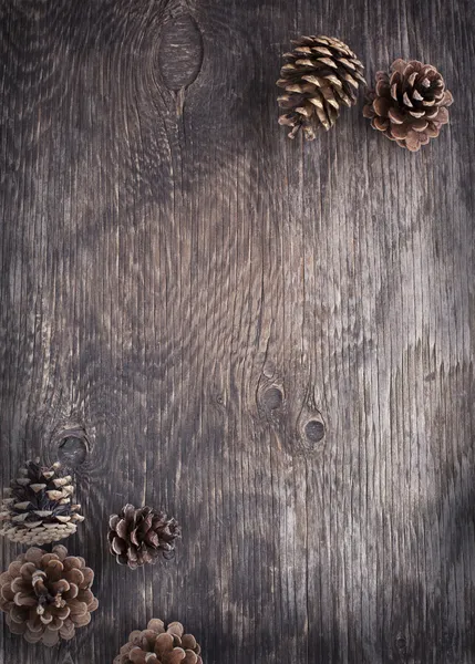 Fondo de madera rústica con conos de pino — Foto de Stock