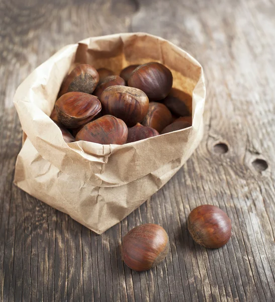 Raw chestnuts on wooden background — Stock Photo, Image