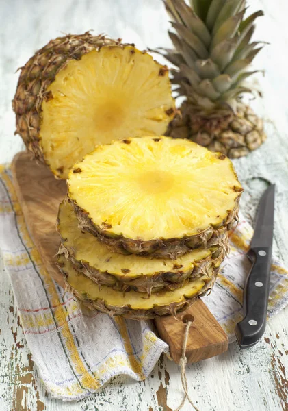 Pineapple with slices on wooden cooking board — Stock Photo, Image