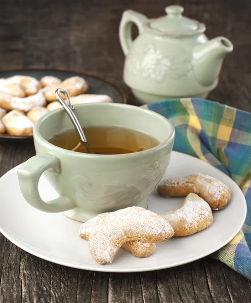 Полумесяцы ванильное и миндальное печенье и чашка зеленого чая — стоковое фото