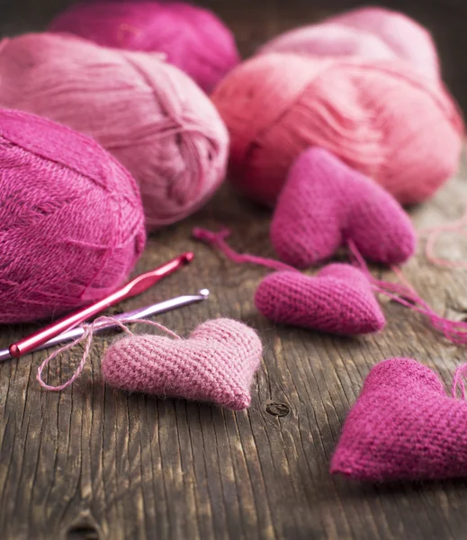 ピンクの心と木製の背景に糸かぎ針編み — ストック写真