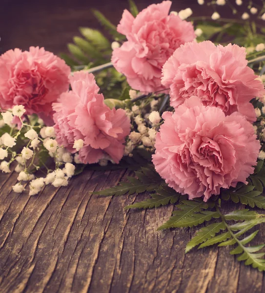 Garofano rosa su sfondo di legno. Immagine tonica — Foto Stock